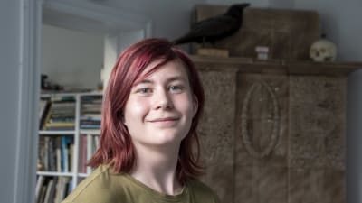 Emil Lehtinen står framför en kakelugn.