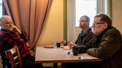 Män äter lunch i ett kafé