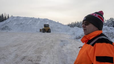 Hannu Pirttinokka står framför det enorma snöberget på snötippen i Borgå.