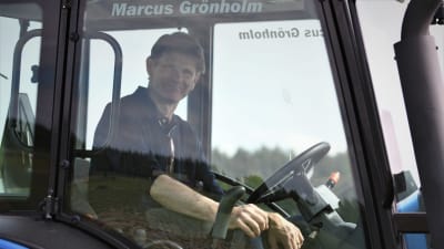 Marcus Grönholm i traktor på åkern utanför hemmet i Ingarskila.