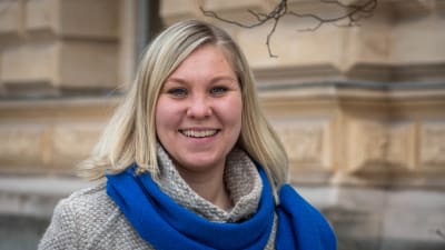En blond kvinna i blå halsduk