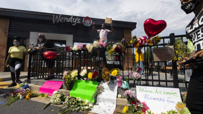 Blommor, hjärtformade ballonger och plakat till minnet av Rayshard Brooks utanför restaurangen Wendy's.
