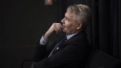 Pekka Haavisto sitter på en stol och tittar åt sidan.