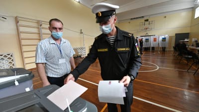 En kadett i uniform röstar i en gymnasiksal i Vladivostok.