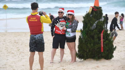 Julfirare poserar på Bondi Beach i Sydney, Australien.