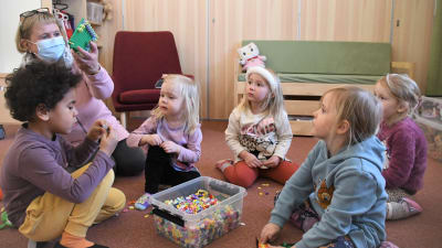 Barn och vuxen leker tillsammans i ett daghem