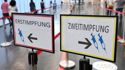 Två tyskspråkiga skyltar som dirigerar till två olika köer beroende på om man är vaccinerad eller ej.