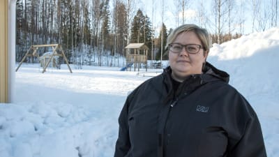 Jannica Ruusunen står på sin gård, i bakgrunden syns en gunga och klätterställning.