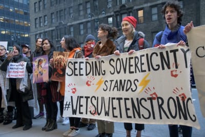 Demonstranter med en skylt där det står "Seeding sovereignty stands Wetsuwetenstrong"