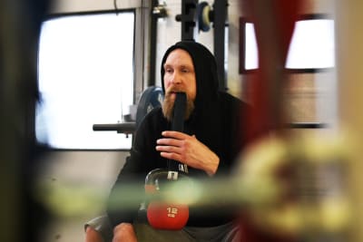 Robert Helenius lyfter en tyng med ett gummiband han har i munnen.