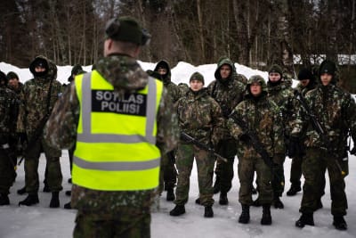 Finska beväringar med vapen framför snöhög