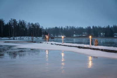 Snötäckta bryggor vid en strand i gryningen