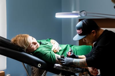 En kvinna som blir tatuerad på armen.