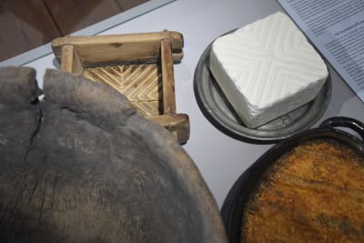 Bondost, en ostform, kålrotslåda och ett träkärl.