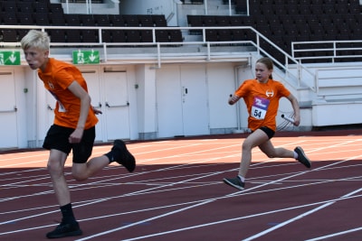 Löpare växlar i Stafettkarnevalen.