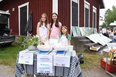 Tre flickor säljer bakverk.