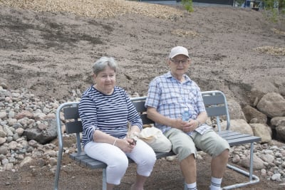 En man och en kvinna sitter på en bänk.
