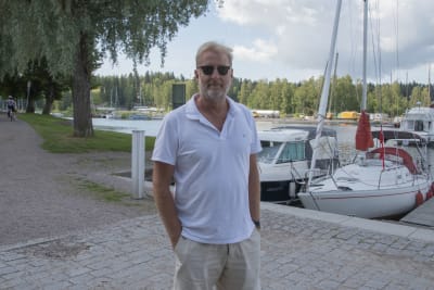 Man med händerna i fickorna tittar in i kameran.