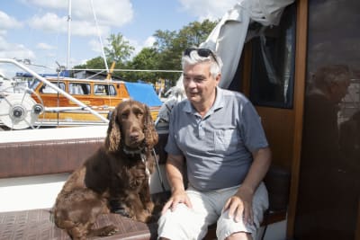 Man och hund sittandes i en båt.