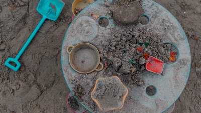 Lasten leikkipöytä hiekkalaatikolla. Pöydällä hiekkakakkuja muotteja.