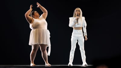 bilal hassani i vit dräkt sjunger bredvid en dansare som för ovanlighetens skull inte är smal