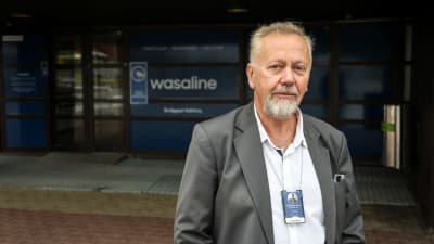Medelålders man står framför en ingång där det står Wasaline.