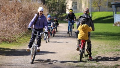 En grupp barn från Ukraina cyklar omkring på en cykelväg.