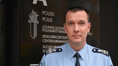 En polis i uniform står utanför polishuset i Åbo.