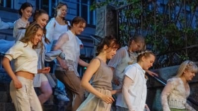 Tanssijat juoksevat vaaleissa vaatteissa alas Sibelius-lukion kivisiä rappuja.