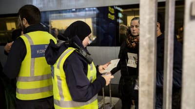 Gränskontrollanter i reflexväst kollar ID på tågpassagerare i Malmö.