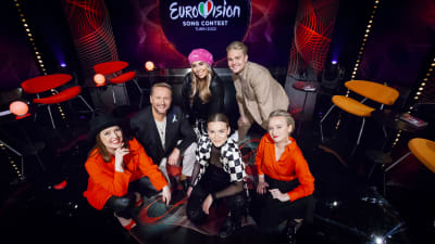 Eva Frantz, Mikko Silvennoinen, Katri Norrlin, Märta Westerlund, Benjamin Peltonen och Petra Laiti sitter på studiogolvet i Eurovisionsbubblan