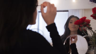Ninni Nguyen applicerar smink hemma vid spegeln.