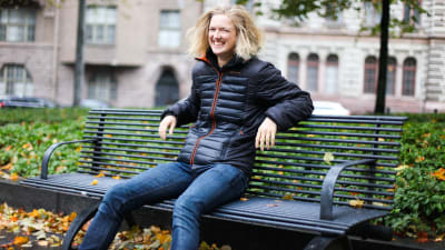 Lisa Gerkman ler mot kameran medan hon sitter på en bänk.