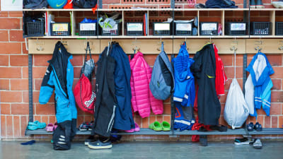 Barnkläder hänger i skolkorridor