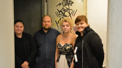 Fyra arrangörer för spökvandringarna står framför ingången till källaren.