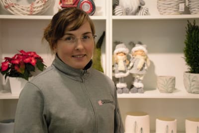 Brunhårig kvinna i 30-års åldern i en butik med julpylar.