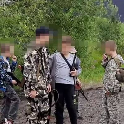 Ryska barn står med vapen och vapenkopior. 
