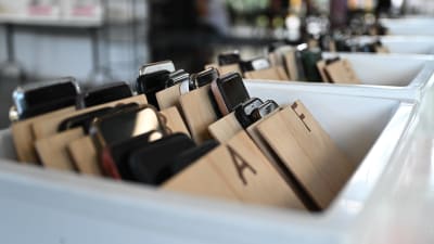 Telefoner i vita plastlådor.