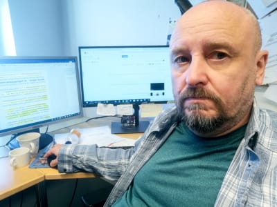 En man sitter framför datorn.
