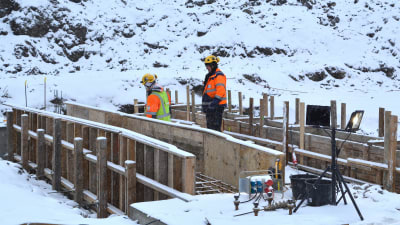byggarbetare jobbar ut i vit vinter