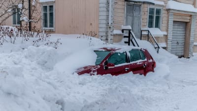 Insnöad bil i snöhög.