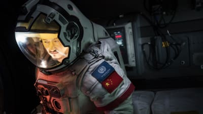 Närbild på Liu Peiqiang (Jing Wu) i rymddräkt.