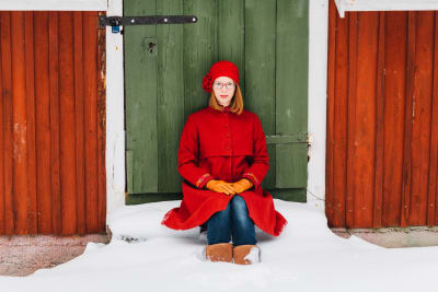 Maria Turtschaninoff sitter vid en grön dörr.