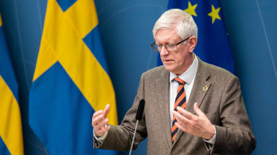 Johan Carlson, generaldirektör på Folkhälsomyndigheten, på pressträff på regeringskansliet framför svenska flaggor.