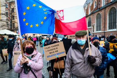 Polska demonstranter bär EU:s och Polens flagga under en manifestation för pressfrihet