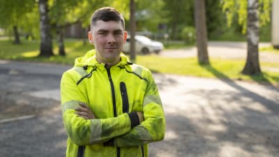 En man klädd i neongula och svarta arbetskläder, Simon Friman,