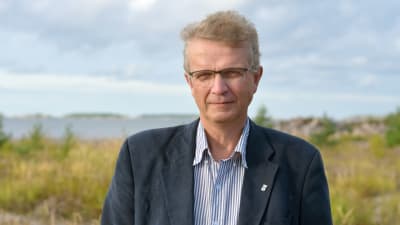 man i blå kavaj ute vid havet