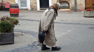 Gammal kvinna på gatan i Vilnius.