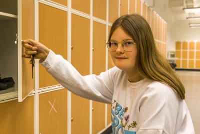 Gymansieleven Alva Wirtanen öppnar sitt skåp i skolans korridor. 