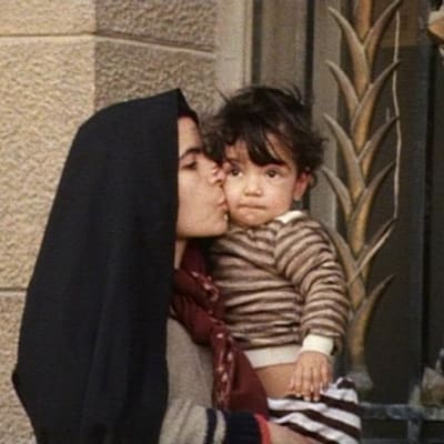 Äiti suukottaa lastaan kadulla Damaskoksessa Syyriassa.